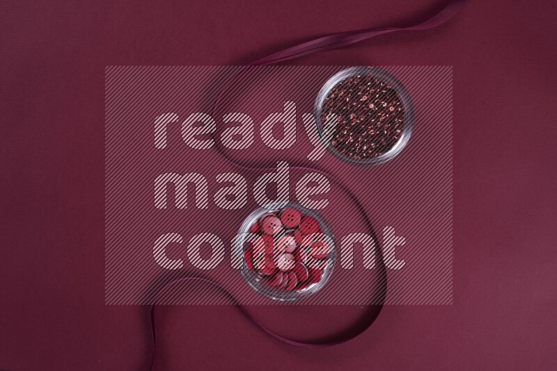 A red collection of sewing and tailoring tools arranged on a red background