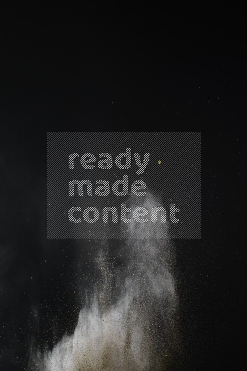 A side view of brown powder explosion on black background