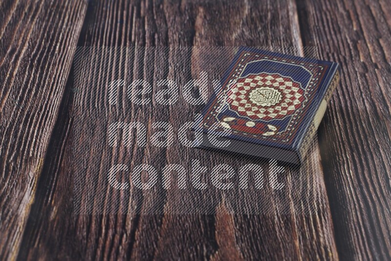 Quran with a prayer beads on wooden background