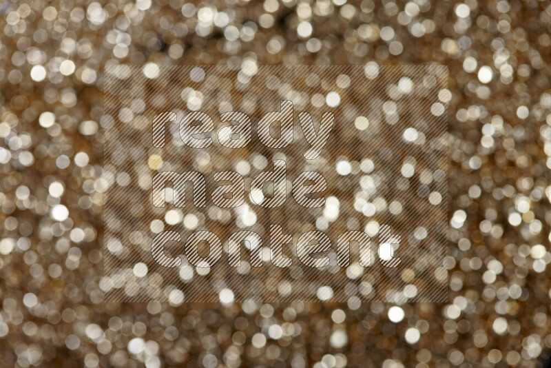 Gold shimmering fragments of glass scattered on a black background