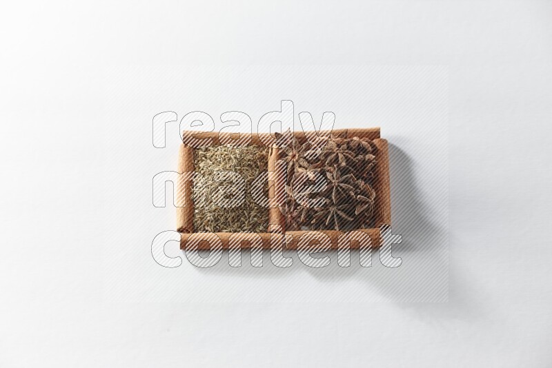 2 squares of cinnamon sticks full of star anise and cumin on white flooring