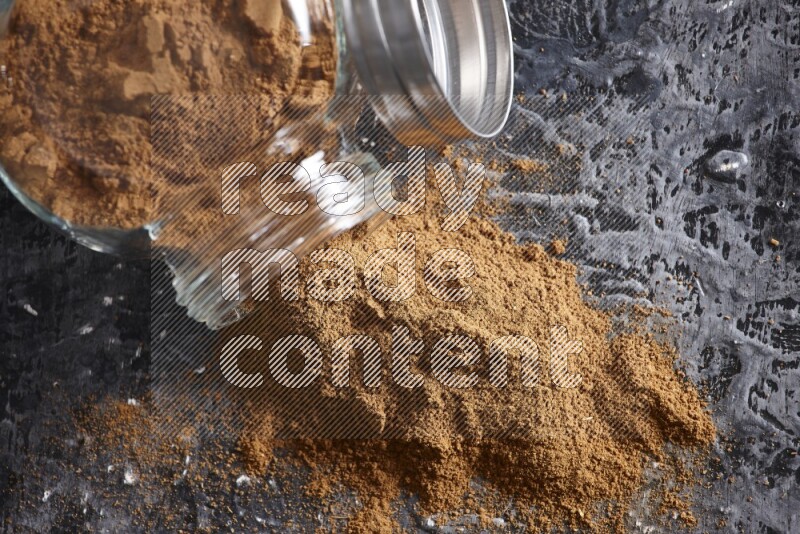 قرفة في وعاء زجاجي مقلوب علي خلفية سوداء