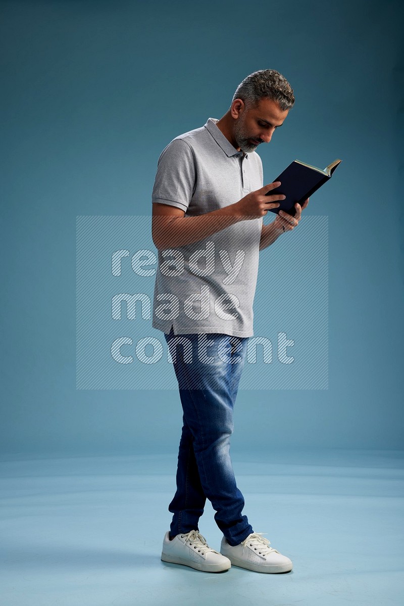 Man Standing reading book on blue background