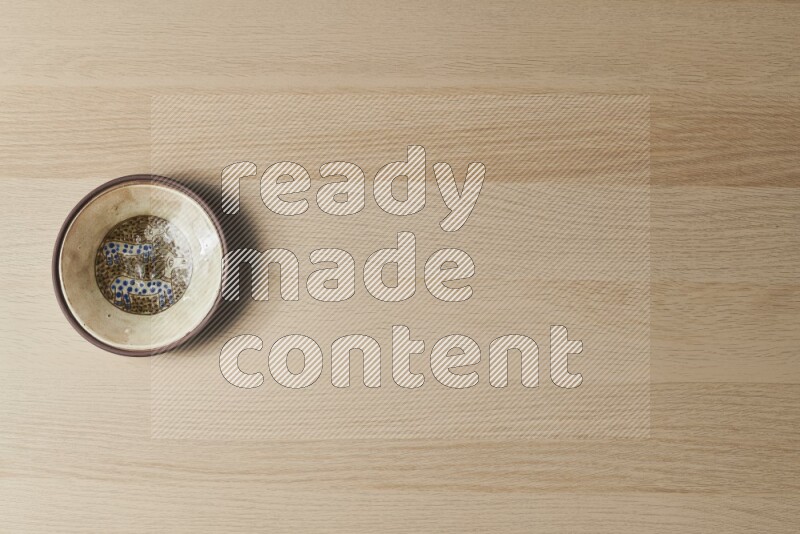A decorative pottery plate on light wooden background