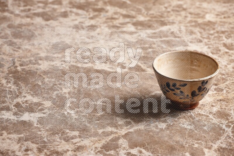 A decorative pottery bowl on beige marble background