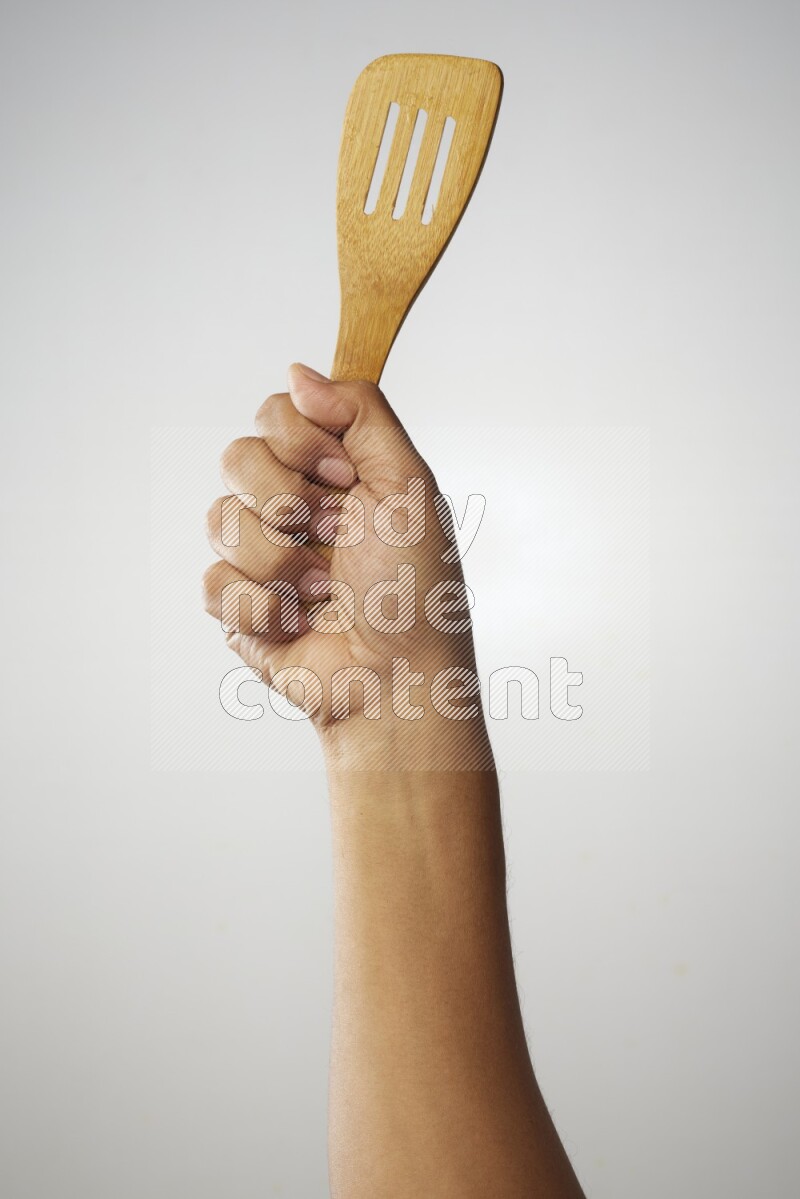 Male Hand Holding Slotted Turner on white background