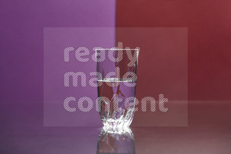 The image features a clear glassware filled with water, set against purple and dark red background