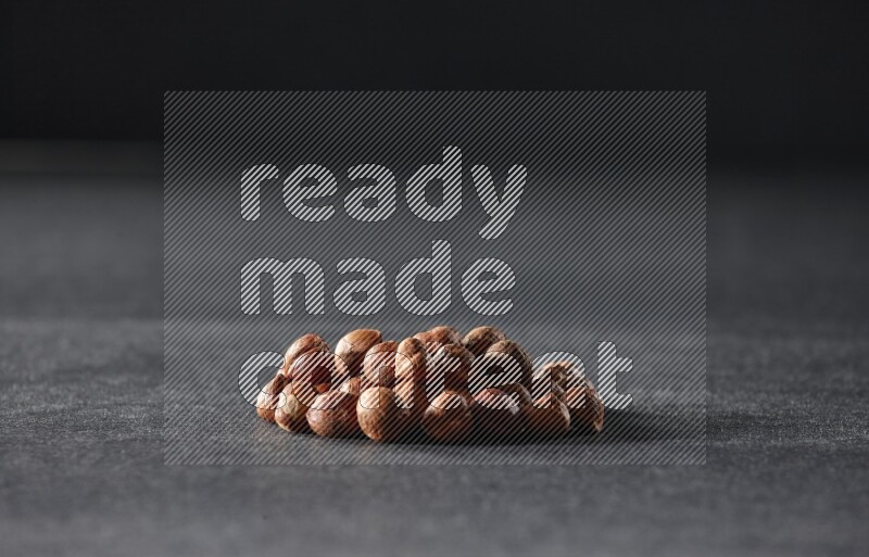 A bunch of peeled hazelnuts on a black background in different angles