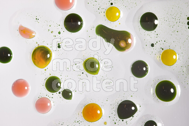 Close-ups of abstract green, yellow and red paint droplets on the surface