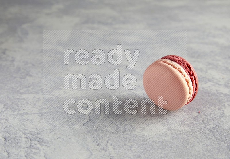 45º Shot of Pink Litchi Raspberry macaron on white  marble background