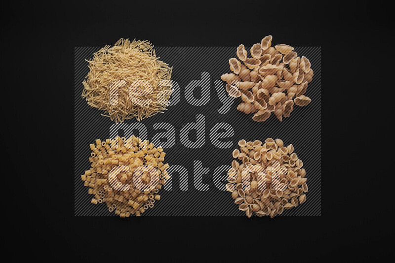 Different pasta types in bunches on black background