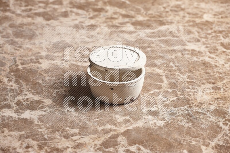 A white pottery bowl on beige marble background
