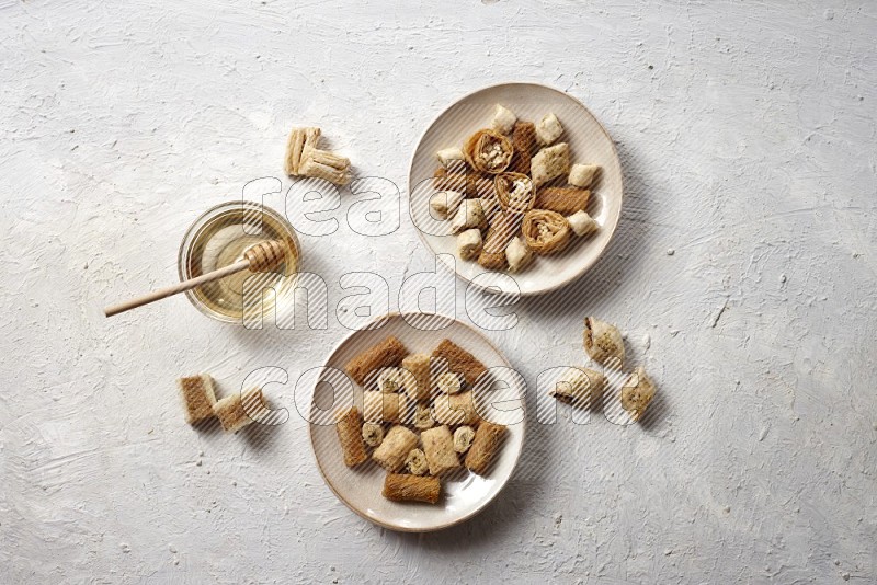 Oriental sweets in pottery plates with honey in a light setup