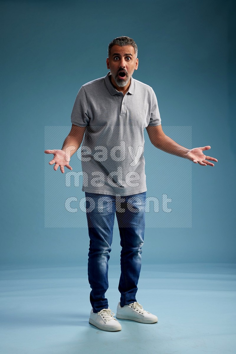 Man Standing Interacting with the camera on blue background