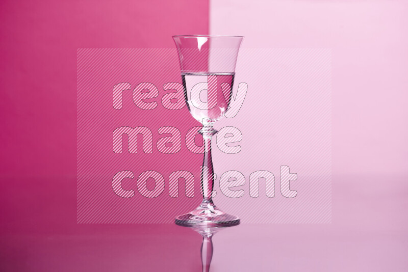 The image features a clear glassware filled with water, set against pink background