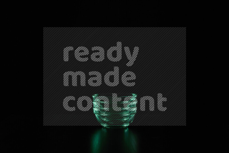 Glassware with rim light in green against black background