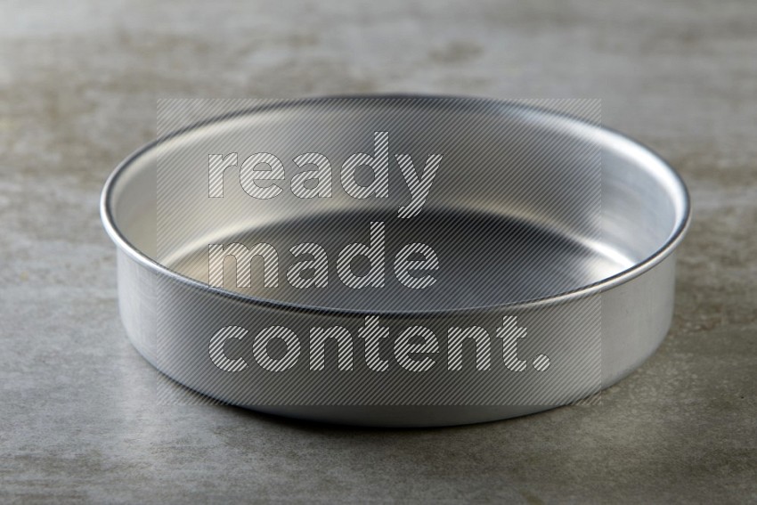 Stainless steel round tray on grey textured counter top