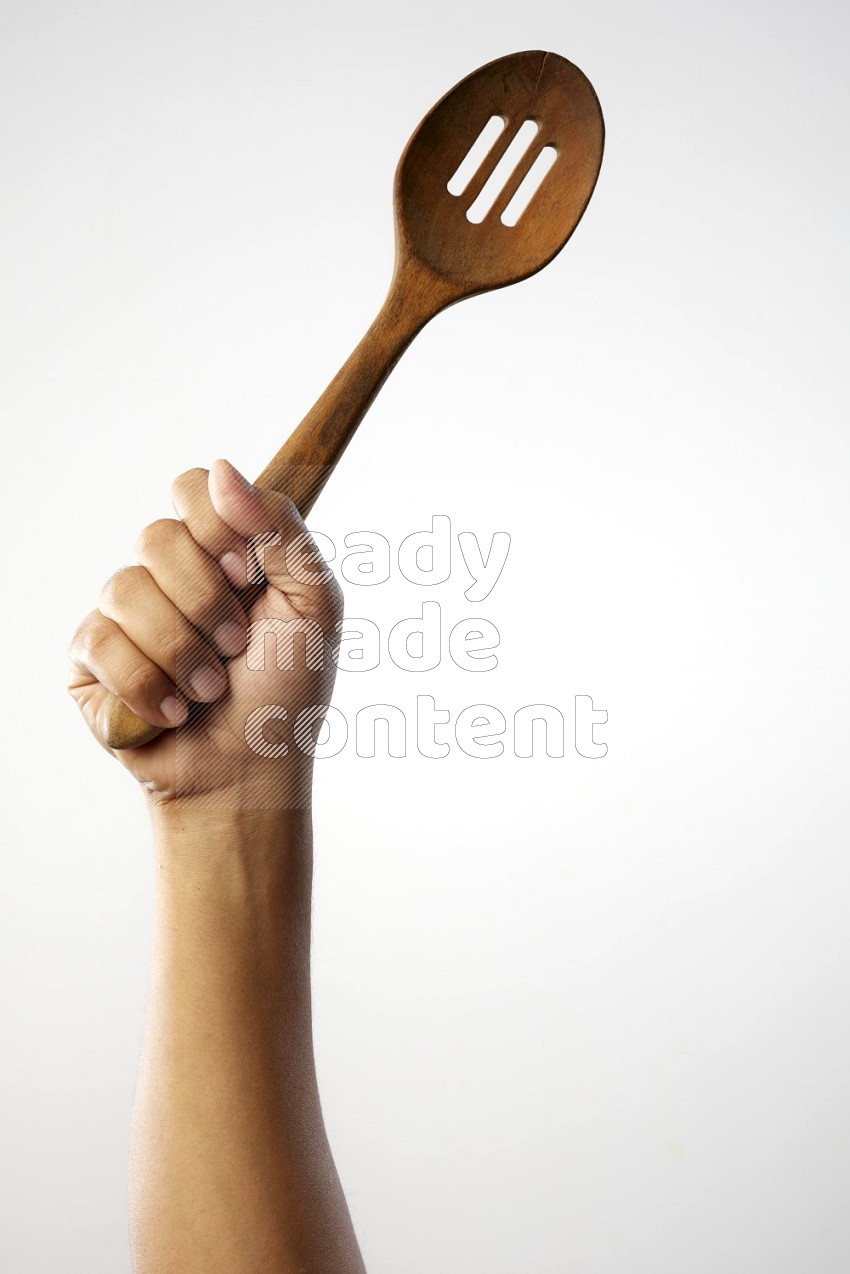 Male Hand Holding Wooden colander spoon  on white background