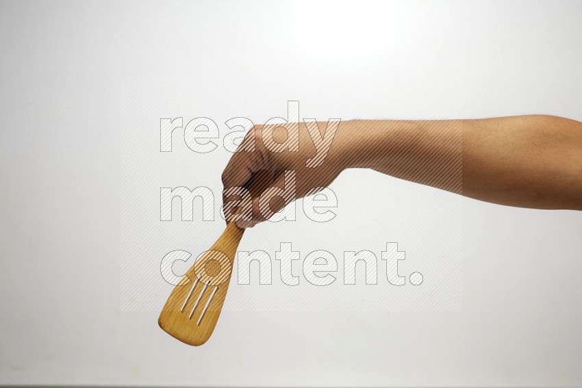 Male Hand Holding Slotted Turner on white background