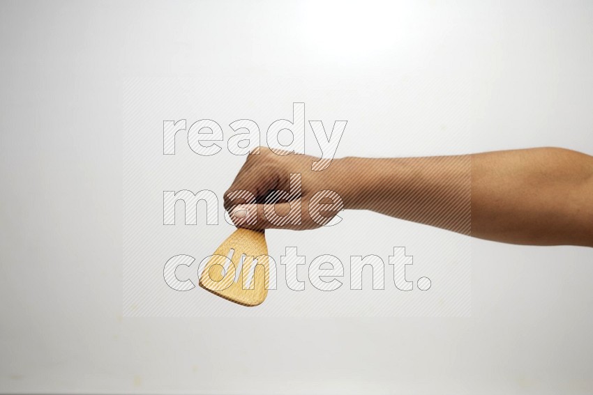 Male Hand Holding Slotted Turner on white background