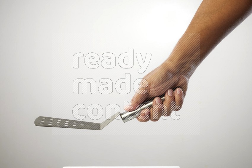 Male Hand Holding Burger Flipper on white background