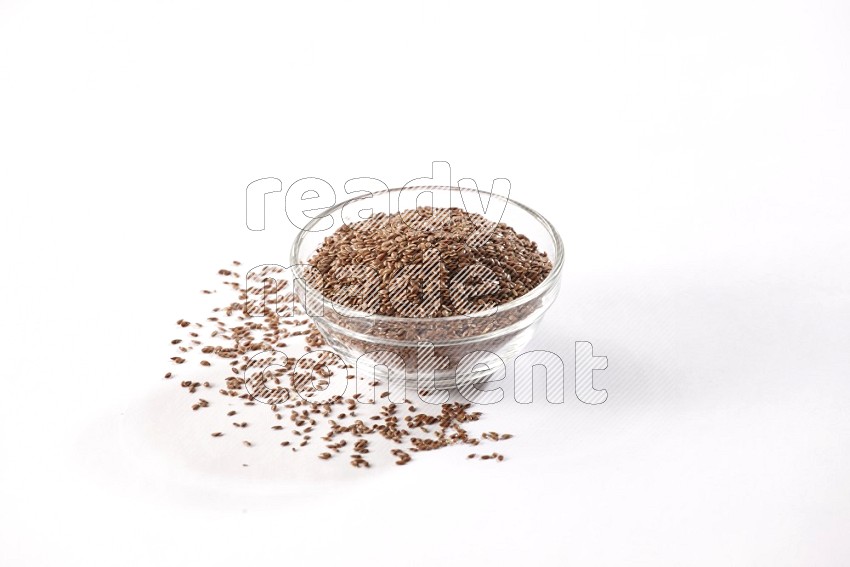 A glass bowl full of flax surrounded by flax seeds on a white flooring in different angles