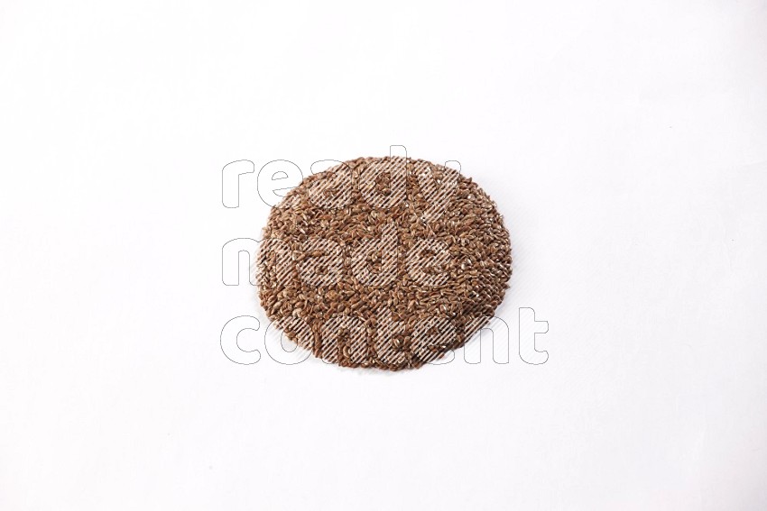 Flax seeds in a circle shape on a white flooring in different angles