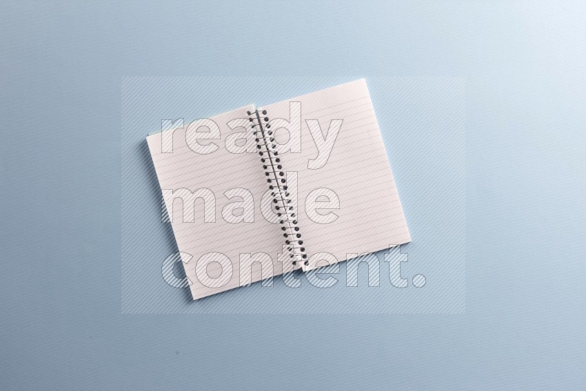 A blank open notebook with school supplies on blue background (Back to school)