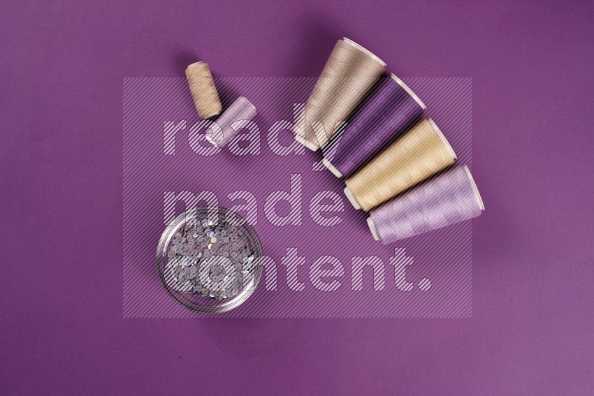 Beige sewing supplies on purple background