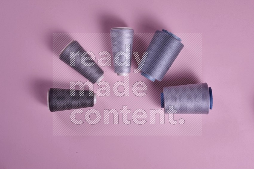 Grey sewing supplies on pink background