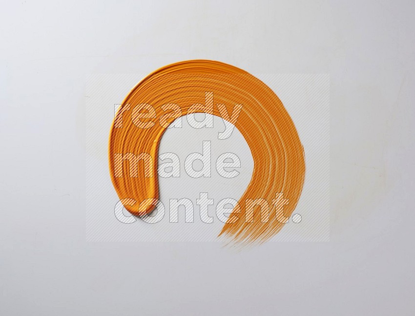 An orange circular painting brush stroke on white background