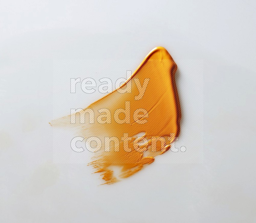 An orange single curved painting knife stroke on white background