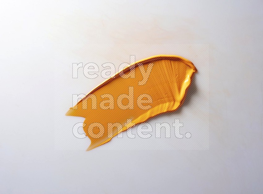 An orange single curved painting knife stroke on white background